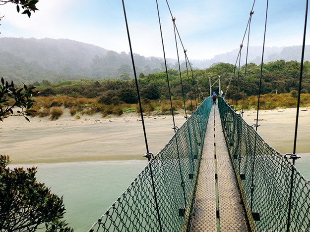 Crossing the suspension bridge to Maori Bay.jpg